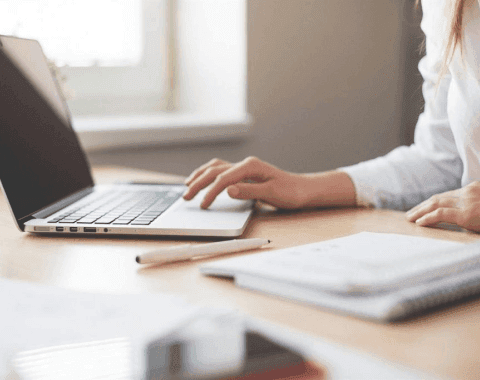 Lawyer working at a desk with a laptop and a notebook